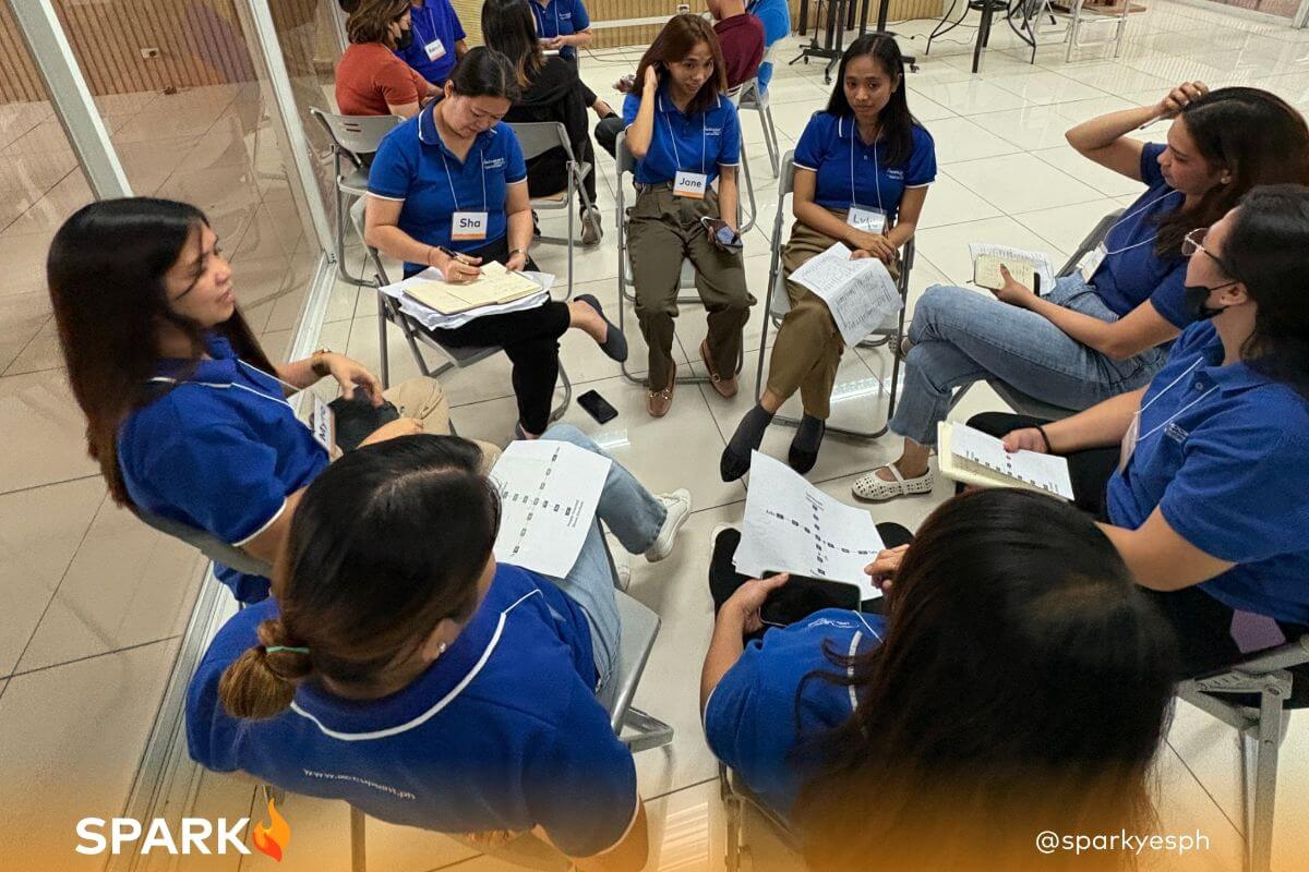 Small group of employees sharing insights from a communication workshop conducted by Spark PH, reflecting collaborative learning and workplace skill development.