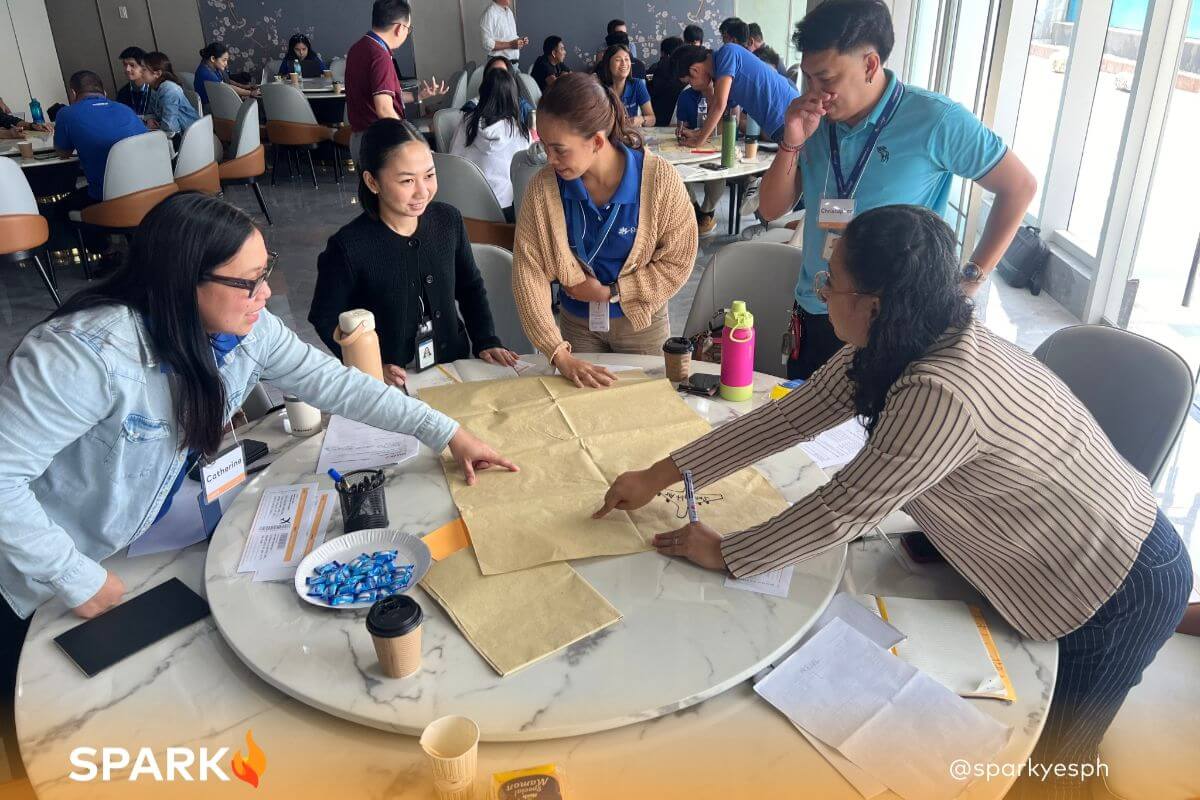 Small group of employees participating in a workshop, engaging in a brief discussion to share ideas and collaborate on workplace topics.