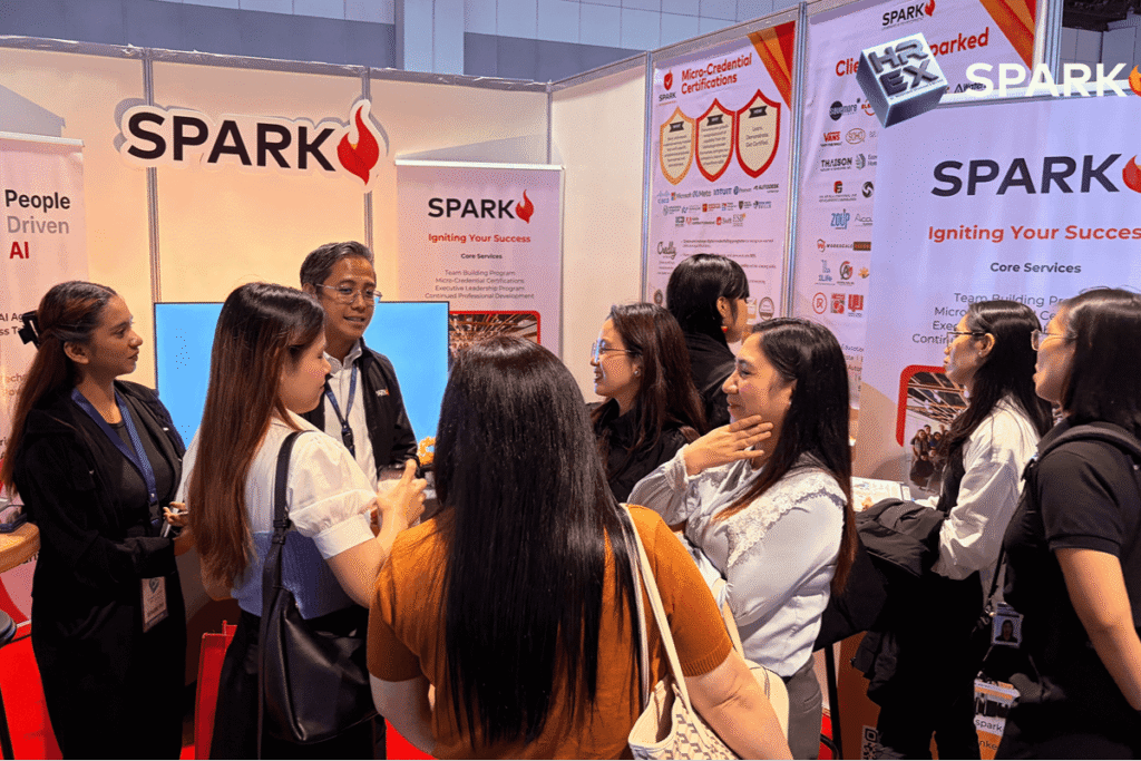 Attendees and staff interacting at the SPARK booth featuring information on micro-credential certifications and corporate training.