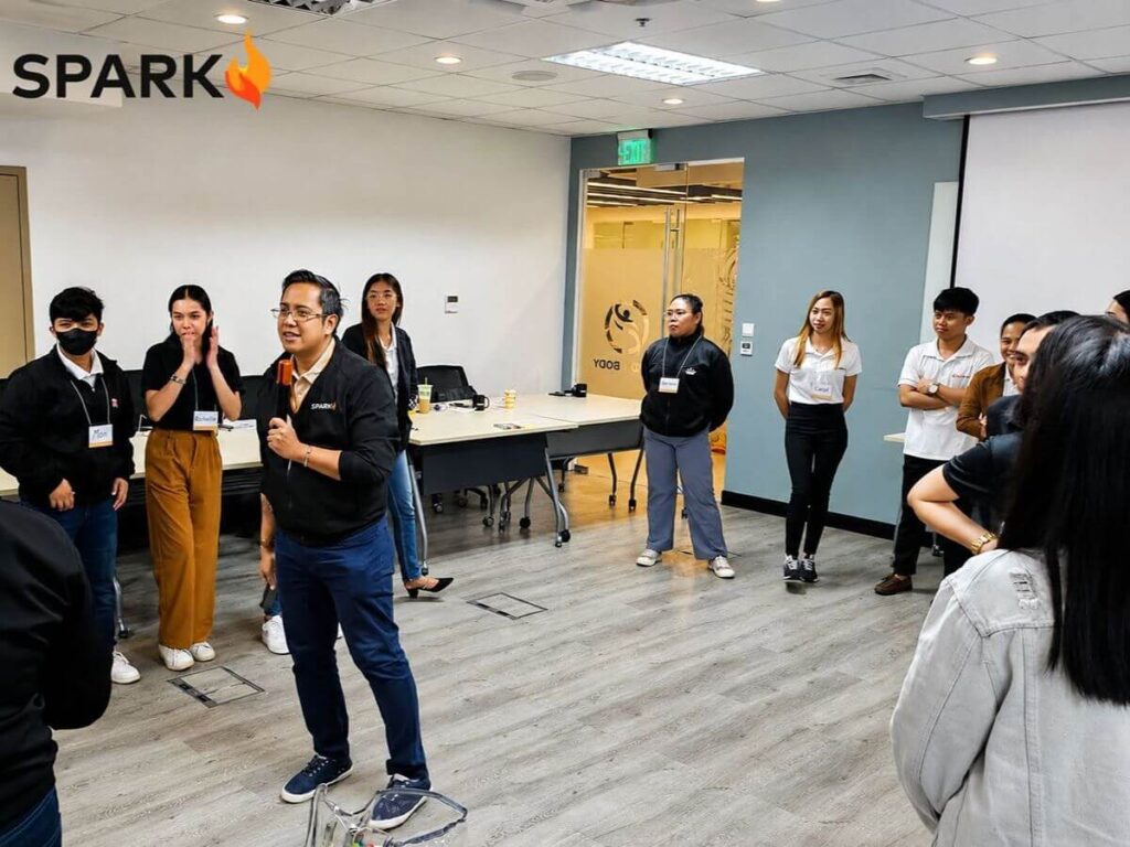Spark PH team-building facilitator guiding employees through an interactive group activity to strengthen communication and teamwork